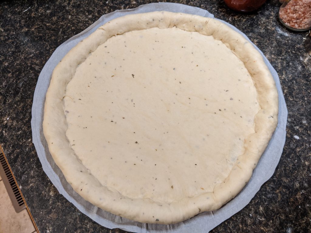 Formed pizza dough with a stuffed crust.