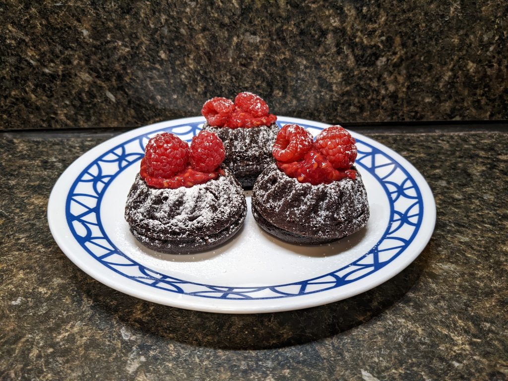 Raspberry-topped miniature chocolate bundt cakes.
